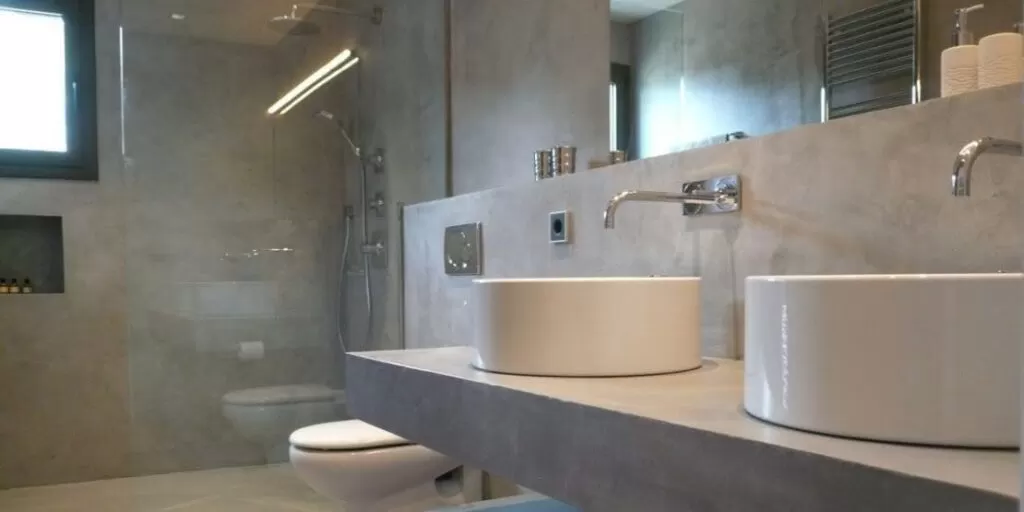 5 ideias para transformar seu banheiro com concreto: Do industrial ao minimalista; Como usar cimento queimado no box do banheiro: Guia completo; Cubas de concreto artesanais: O toque de luxo que seu lavabo precisa; Metais pretos e grafite: A combinação perfeita para banheiros de concreto; Elementos naturais no banheiro de concreto: Traga aconchego e sofisticação.