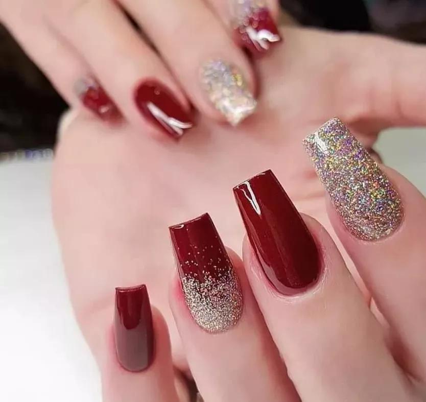 unha anelar dourada com glitter vermelho